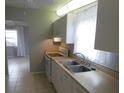 Efficient kitchen with white cabinets and appliances at 4011 W Mango Ave, Tampa, FL 33616