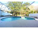 Relaxing kidney-shaped pool with a screened enclosure at 4634 Mapletree Loop, Wesley Chapel, FL 33544
