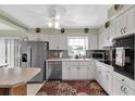 Bright kitchen featuring white cabinets, stainless steel appliances, and a floral rug at 6650 Hickorywood Ln # 6650, New Port Richey, FL 34653