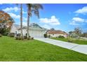 Landscaped yard with a paved driveway leading to a two-car garage at 7290 Rosemont Ln, Spring Hill, FL 34606