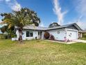 Nice curb appeal! This Florida home features a gray roof and a well-maintained lawn at 8015 Pequena Dr, Port Richey, FL 34668
