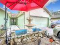Landscaped front yard with fountain and red umbrella at 12529 Shadow Ridge Blvd, Hudson, FL 34669