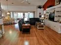 Spacious living room with hardwood floors, leather furniture, and built-in shelving at 18049 Tarrington Pl, Hudson, FL 34667