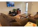 Living room features brown couches, a coffee table, and a large TV at 21103 Patio View Ct # 3105, Lutz, FL 33558