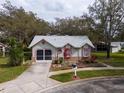 Single story house with grey roof, red accents, and a screened garage at 4912 Enfield Ct, New Port Richey, FL 34655
