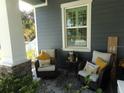 Inviting front porch with wicker chairs and yellow pillows at 6216 Montana Ave, New Port Richey, FL 34653