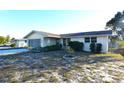 Ranch home with a flat roof, light-colored exterior, and a small front yard at 7714 Jasmine Blvd, Port Richey, FL 34668