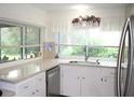 Bright kitchen featuring white cabinets, stainless steel appliances, and ample counter space at 8603 Forest Glade Dr, Hudson, FL 34667