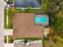 House with a brown roof, pool, and a spacious backyard at 9105 Flagstick Ln, Hudson, FL 34667