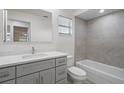 Modern gray bathroom with a bathtub, toilet and vanity at 1355 Powderpuff Dr # 908, Dunedin, FL 34698