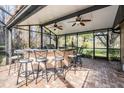 Outdoor screened-in pool bar with seating for entertaining at 1413 Morning Rose Pl, Trinity, FL 34655