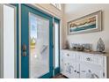 Bright entryway with teal door, decorative console table, and beach-themed art at 3215 Rose Arbor Dr, Hernando Beach, FL 34607