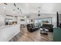 Open living space with hardwood floors, leather couches, and access to a balcony at 3215 Rose Arbor Dr, Hernando Beach, FL 34607