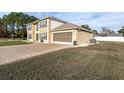 Two-story house with tan exterior, gray shutters, and a paved driveway at 4332 Lamson Ave, Spring Hill, FL 34608
