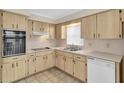 Bright kitchen featuring wood cabinets, built-in appliances, and tile floor at 6033 Wilds Dr # B07, New Port Richey, FL 34653
