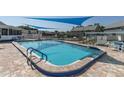 Refreshing community pool with patio furniture under shade sails at 6033 Wilds Dr # B07, New Port Richey, FL 34653