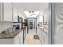 Bright kitchen with white cabinets, granite counters, and black appliances at 6663 Water Oak Ct, Spring Hill, FL 34606
