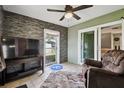 Bright sunroom with sliding glass doors and stone feature wall at 8446 Braganza St, Spring Hill, FL 34608