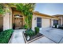 Brick house exterior with double doors, a two-car garage, and lush landscaping at 9338 Clearmeadow Ln, New Port Richey, FL 34655