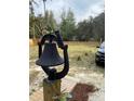 Large backyard with a bell, a wooden fence, and a partial view of a vehicle at 11743 Purdue St, New Port Richey, FL 34654