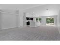 Open living space with gray carpeting, an island kitchen, and a view into the kitchen area at 12040 Pine Warbler Ave, Brooksville, FL 34614
