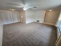 Bright living room featuring carpeted floors and ceiling fan at 13017 Willoughby Ln, Hudson, FL 34667