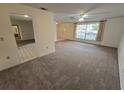 Living room with carpeted floors and access to the front door and other rooms at 13017 Willoughby Ln, Hudson, FL 34667