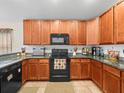 Well-equipped kitchen featuring granite countertops and black appliances at 14284 Finsbury Dr, Spring Hill, FL 34609