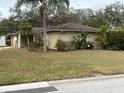 House exterior with tan colored walls, brown roof, and landscaping at 3039 Sandpiper Ct, Clearwater, FL 33762
