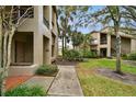 Pathway to condo entrance, with lush landscaping and neighboring building visible at 3053 Landmark Blvd # 1104, Palm Harbor, FL 34684