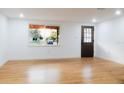 Bright and airy living room with wood flooring and a view to outside at 4852 Capron St, New Port Richey, FL 34653