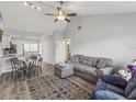 Open living and dining area with gray sectional sofa and wood-look floors at 6428 Gloria Dr # 26, New Port Richey, FL 34653