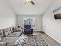 Living room with gray sectional sofa, recliner, and wood-look floors at 6428 Gloria Dr # 26, New Port Richey, FL 34653