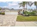 Stunning curb appeal with a three car garage and lush landscaping at 8831 Bel Meadow Way, Trinity, FL 34655