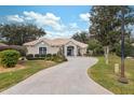 Exterior view of a one-story house with a driveway and landscaping at 9090 Alexandria Dr, Weeki Wachee, FL 34613