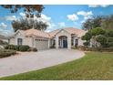 House exterior, showcasing a tile roof, landscaping, and a paved driveway at 9090 Alexandria Dr, Weeki Wachee, FL 34613