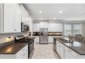 Modern kitchen with white cabinets, granite counters, and stainless steel appliances at 9173 Shadyside Ln, Land O Lakes, FL 34637