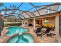 Inviting pool and spa with covered patio and lounge chairs at 9323 Bella Vita Cir, Land O Lakes, FL 34637