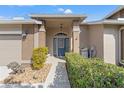Front entrance with a blue door, brick facade, and manicured hedges at 1392 Summerwood Ct, Spring Hill, FL 34606