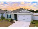 Newly built home with gray exterior, two-car garage, and landscaped yard at 14506 Whitewater Way, Brooksville, FL 34604