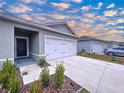 House exterior showcasing a two-car garage and well-maintained landscaping at 14506 Whitewater Way, Brooksville, FL 34604