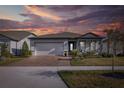 Two-story home with covered porch and landscaped yard at sunset at 18879 Sailors Delight Pass, Land O Lakes, FL 34638