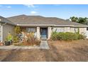 House exterior featuring a blue front door and well-maintained landscaping at 4372 Odin St, Spring Hill, FL 34608