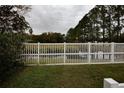Backyard with white fence overlooking a pond and trees at 4649 Westerly Dr, New Port Richey, FL 34653