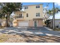 Two-story yellow house with balcony, garage, and well-maintained yard at 5287 Tuna Ln, Weeki Wachee, FL 34607