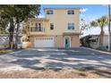 Two-story yellow house with balcony, garage, and spacious driveway at 5287 Tuna Ln, Weeki Wachee, FL 34607