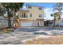 Two-story yellow house with balcony, garage, and spacious driveway at 5287 Tuna Ln, Weeki Wachee, FL 34607