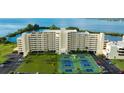 Aerial view of waterfront condo building with tennis courts and parking at 5915 Sea Ranch Dr # 501, Hudson, FL 34667