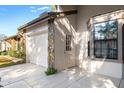 Exterior detail of the villa, showcasing a side entrance and stone accents at 6611 Sovereign Way, Spring Hill, FL 34606