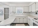 White kitchen with ample cabinetry and a peninsula countertop at 7037 Versailles N # 15, Pinellas Park, FL 33781